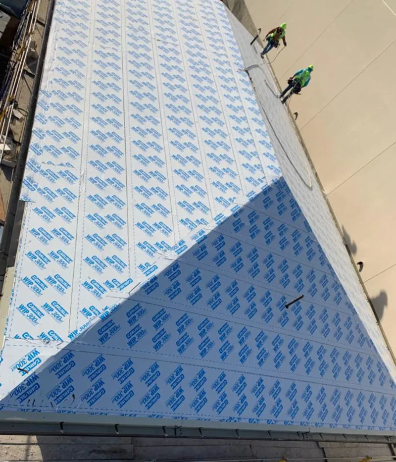 Professional roofers installing underlayment on a metal roof in Brockport